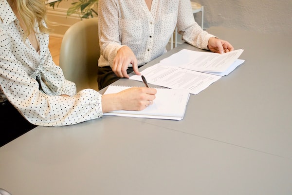 A personal injury lawyer speaking with a client signing paperwork for a personal injury case.